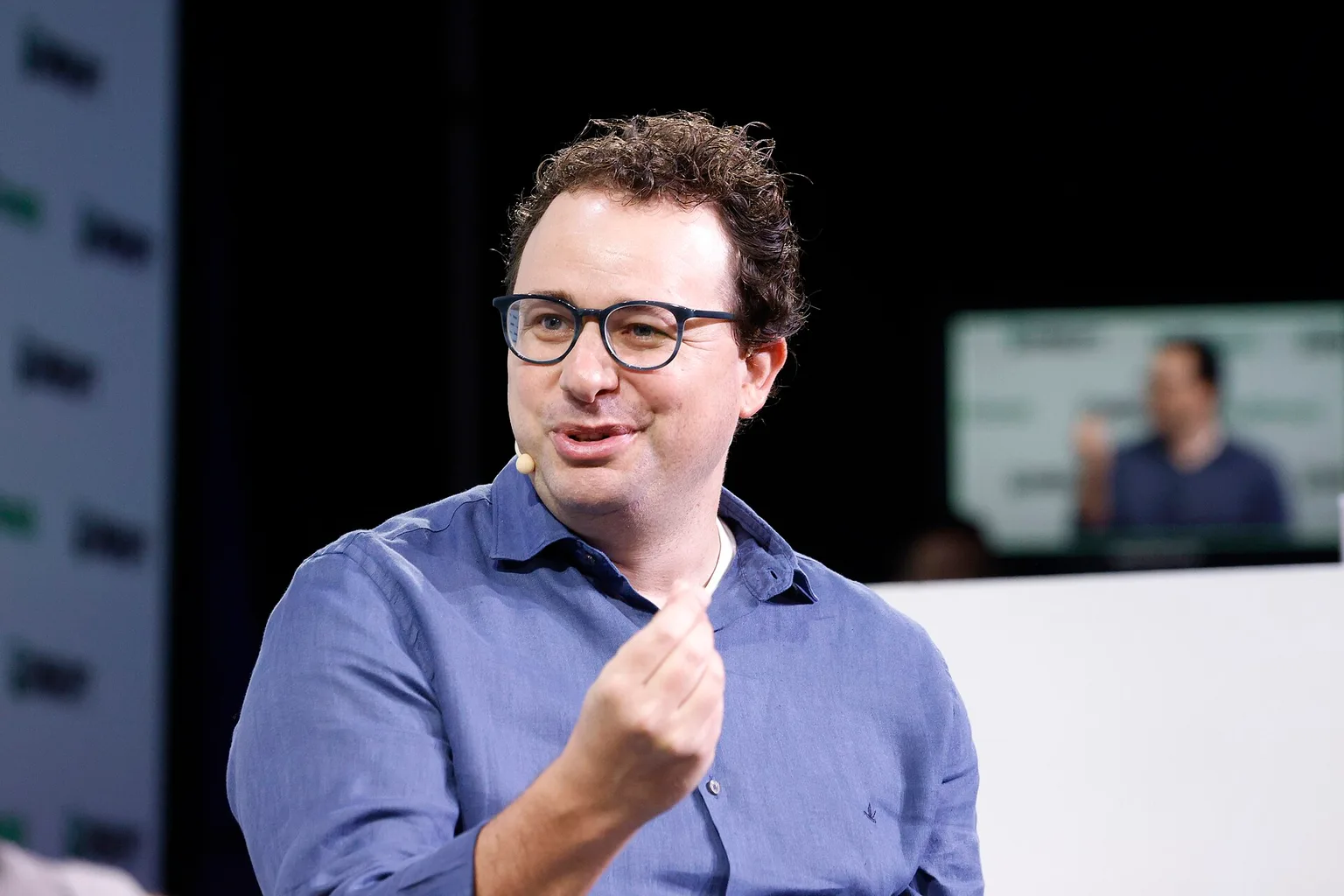 Anthropic CEO Dario Amodei gesturing as he speaks on stage at TechCrunch Disrupt 2023